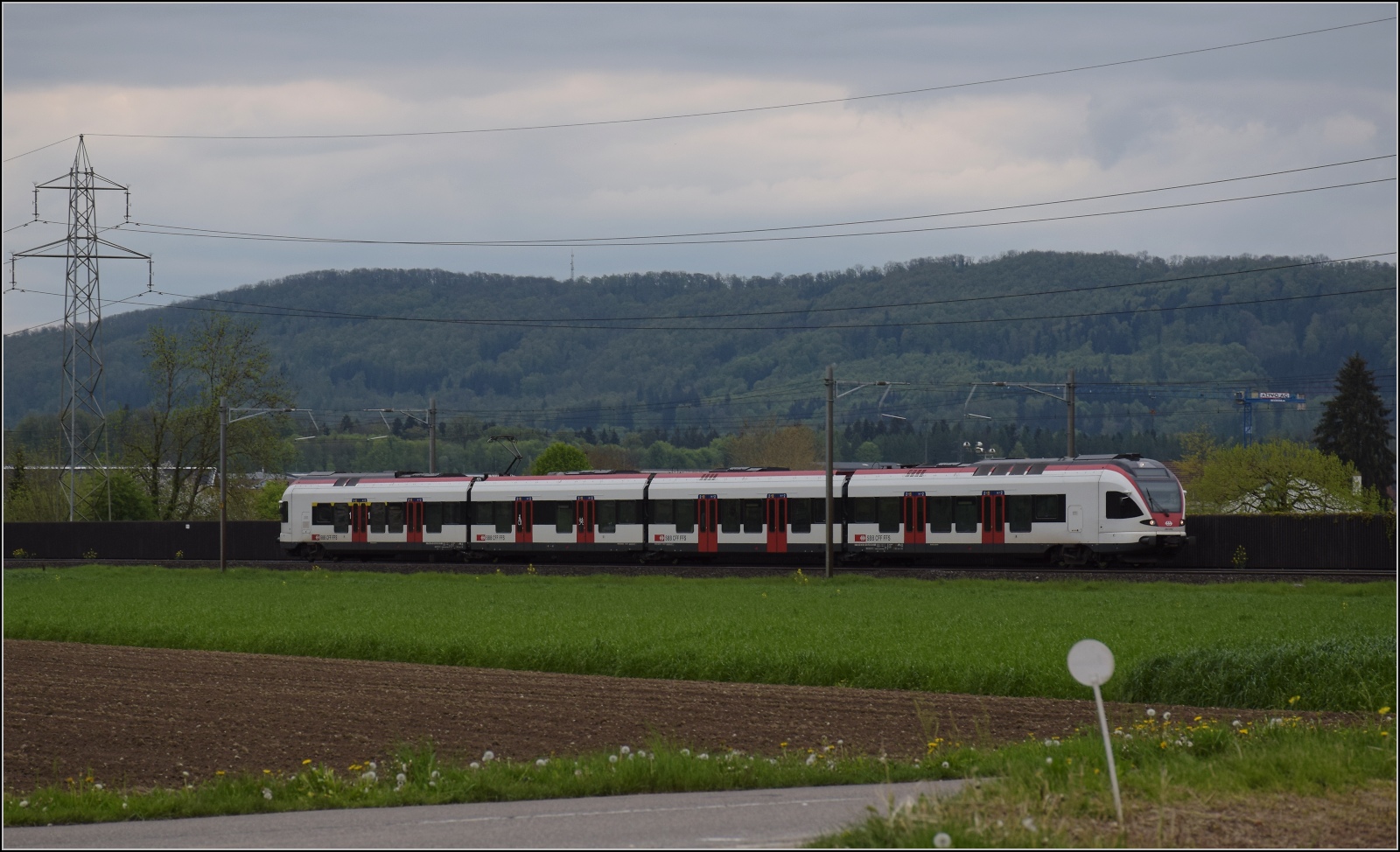 RABe 523 072 bei zwischen Henschiken und Dintikon-Dottikon. April 2023.