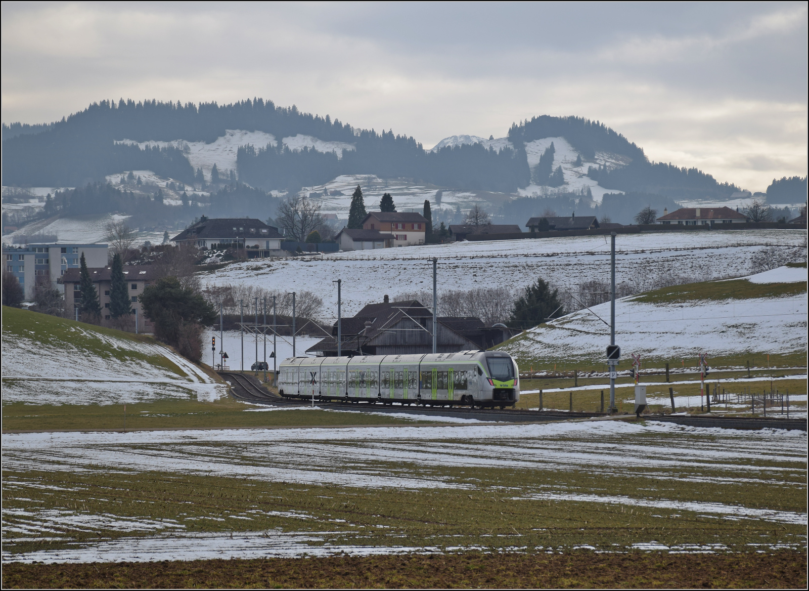 RABe 528 213 ist kein Mika sondern KAMI und bei Häusern auf dem Weg nach Schwarzenburg. Januar 2026.