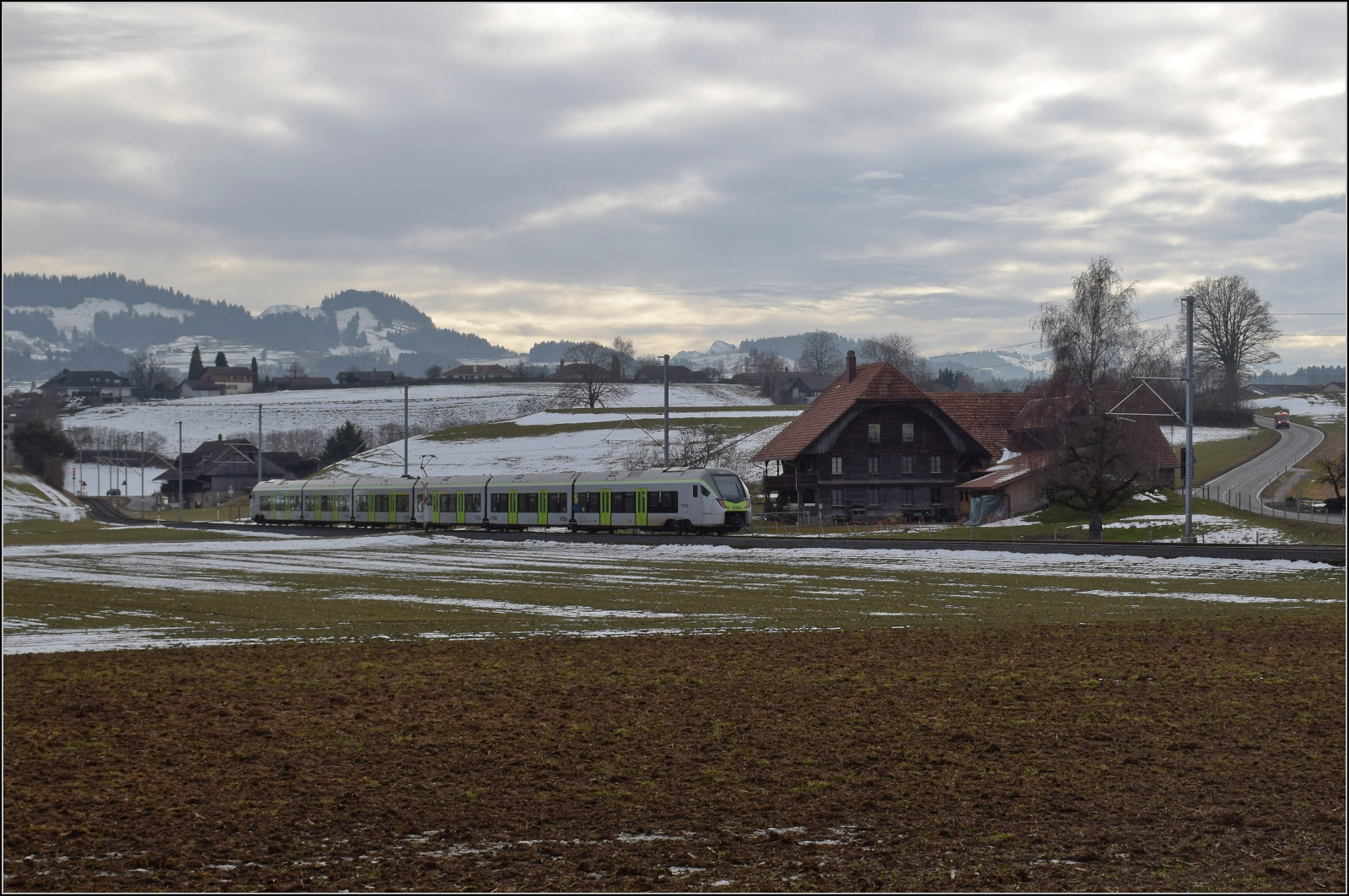 RABe 528 213 ist kein Mika sondern KAMI und bei Häusern auf dem Weg nach Schwarzenburg. Januar 2026.