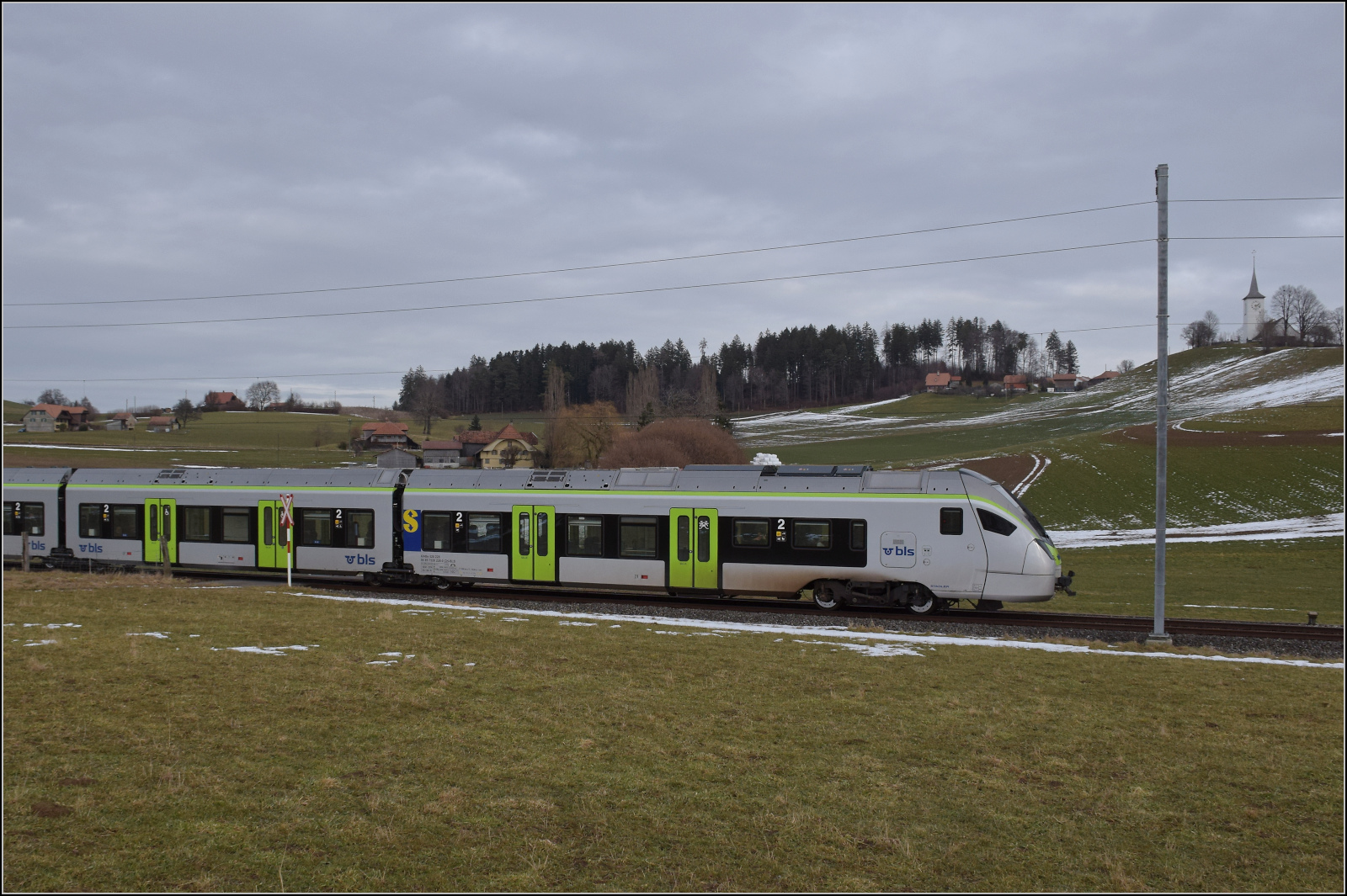 RABe 528 228 bei Häusern auf dem Weg nach Bern. Januar 2026.