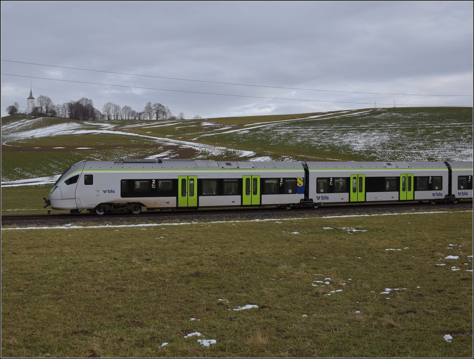 RABe 528 228 bei Häusern auf dem Weg nach Bern. Januar 2026.