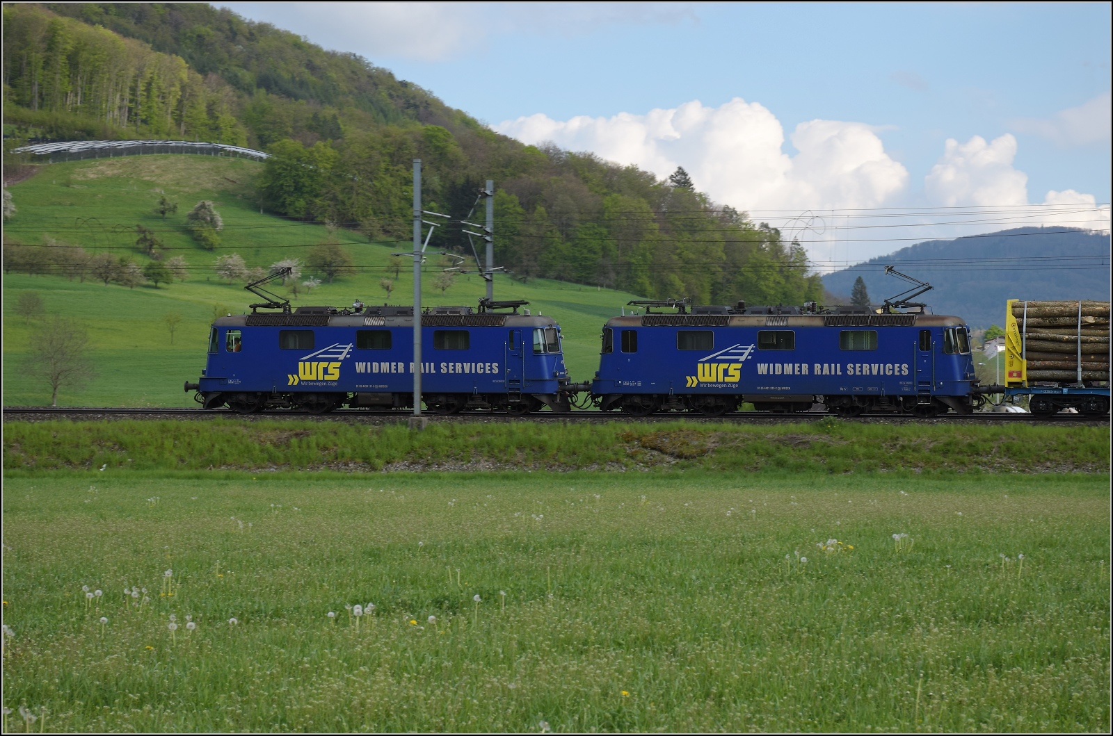 Re 430 111 WRS und Re 421 373 WRS mit einem beladenen Holzzug. Thürnen, April 2022.