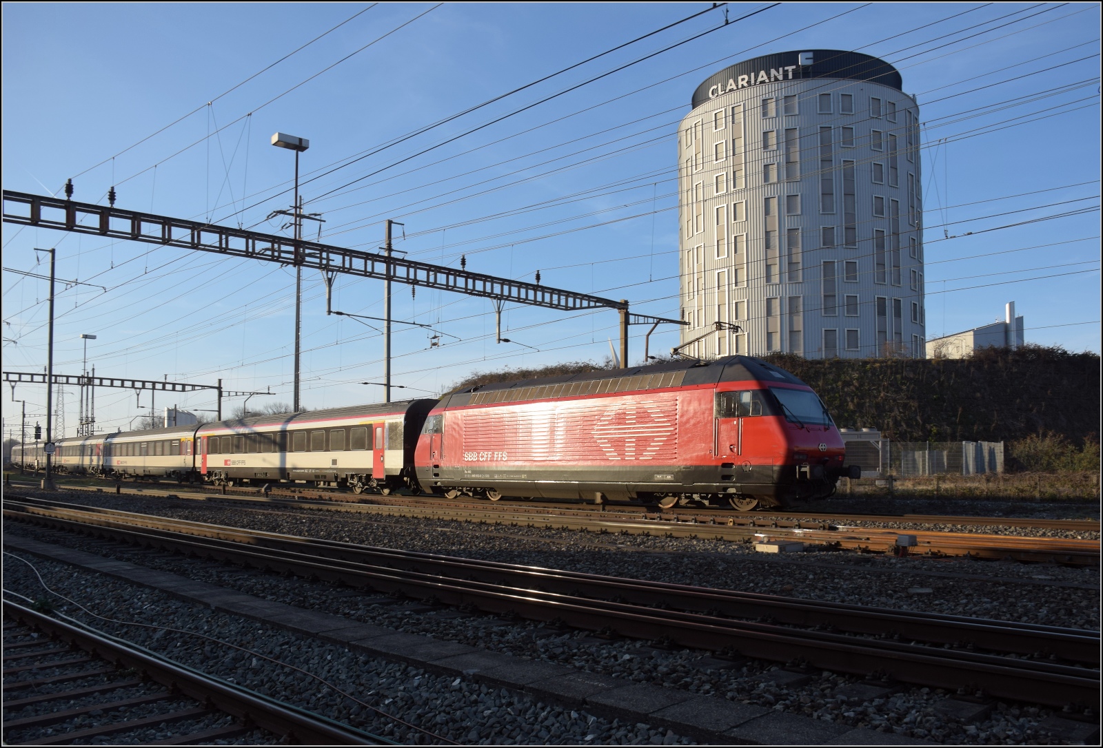 Re 460 012 'Erguël' mit einem Interregio nach Basel in Pratteln. Februar 2023.