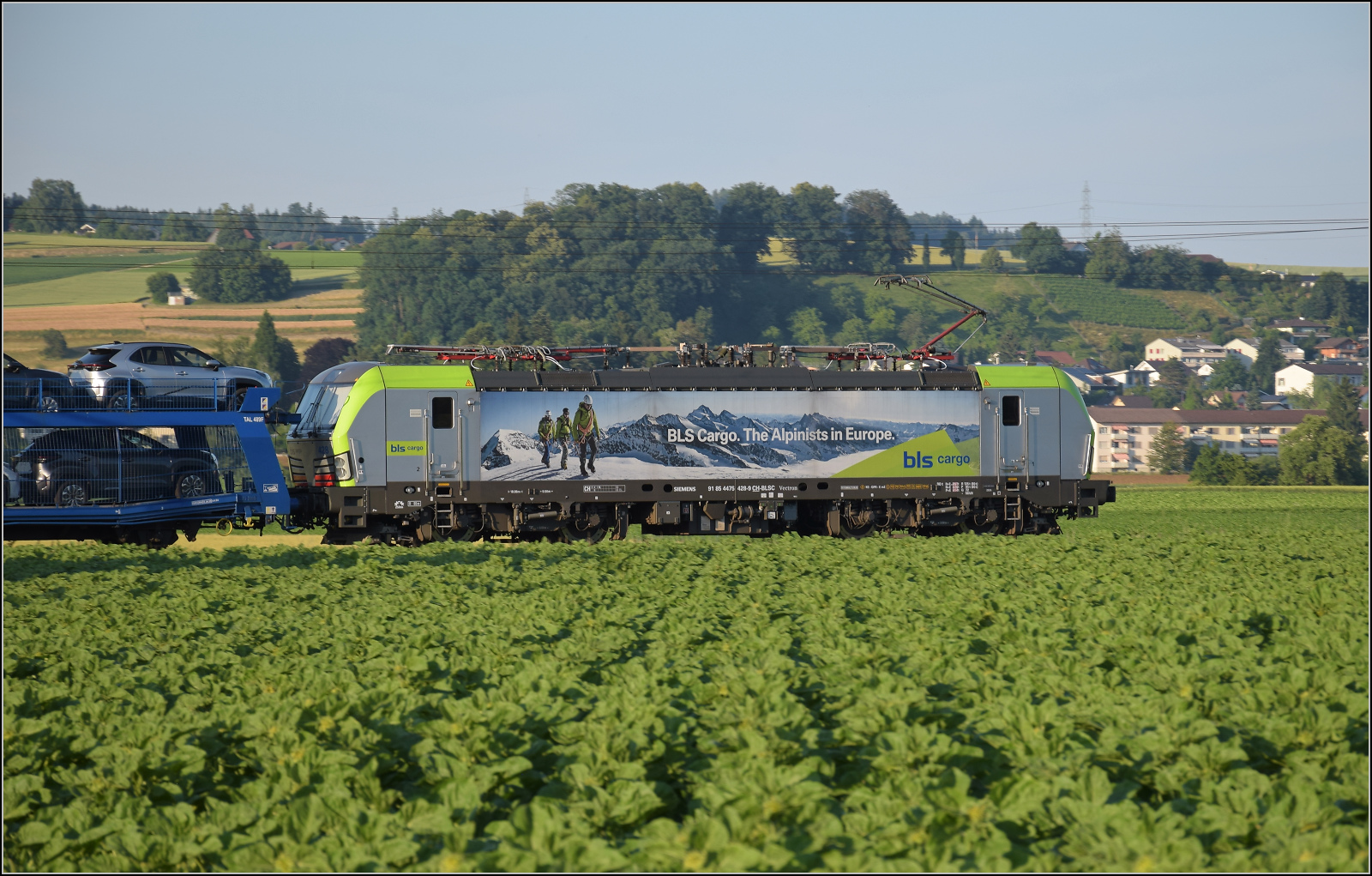 Re 475 428 aus der dritten Serie Vectronen für die BLS mit einem Autozug bei Hendschiken, Juni 2025.