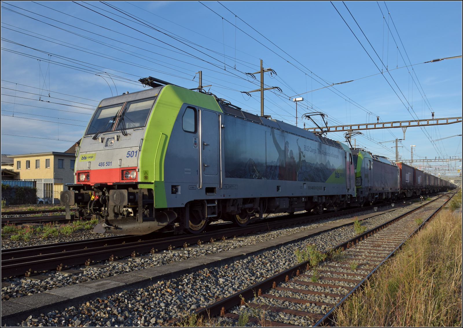 Re 486 501 und Re 475 410 in Pratteln. August 2026.