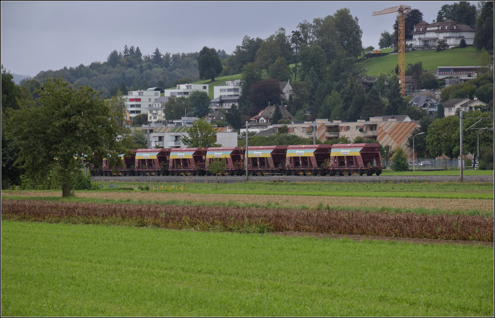 Re 6/6 11659 'Chavornay' zieht einen Kieszug an den Gemeindegrenzen Bittnau, Wikon und Zofingen vorbei. August 2017.