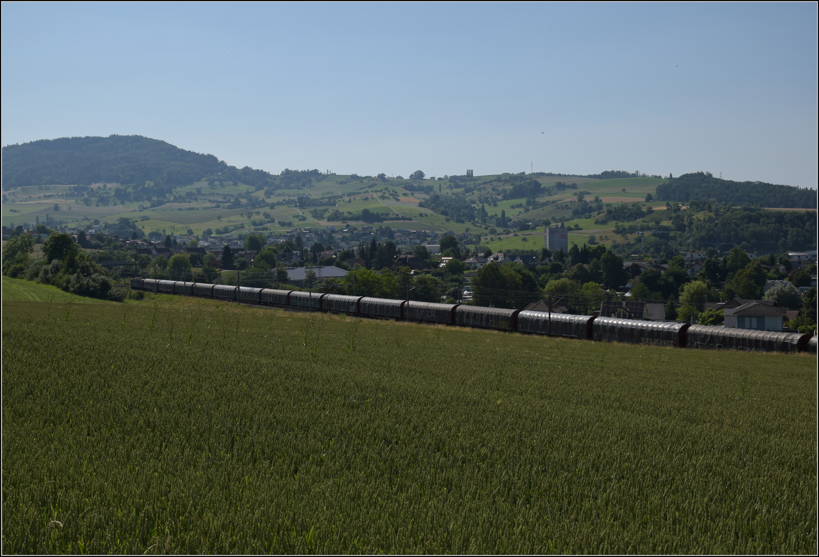 Re 6/6 11678 'Bassersdorf' mit Planenwagen bei Frick, Juni 2025.
