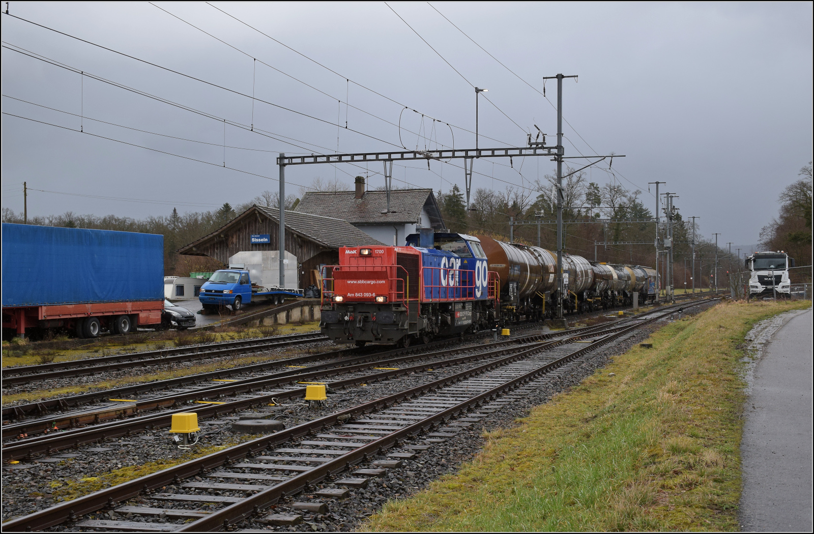 Schlechtwetter bei Sisseln. 

Am 843 093 darf mit einigen G�terwagen offenbar erst abfahren, nachdem RABe 523 011 und RABe 521 014 in Laufenburg angekommen sind. Die signaltechnische Ausstattung der aargauischen Hochrheinbahn ist eher spatanisch. Februar 2026.