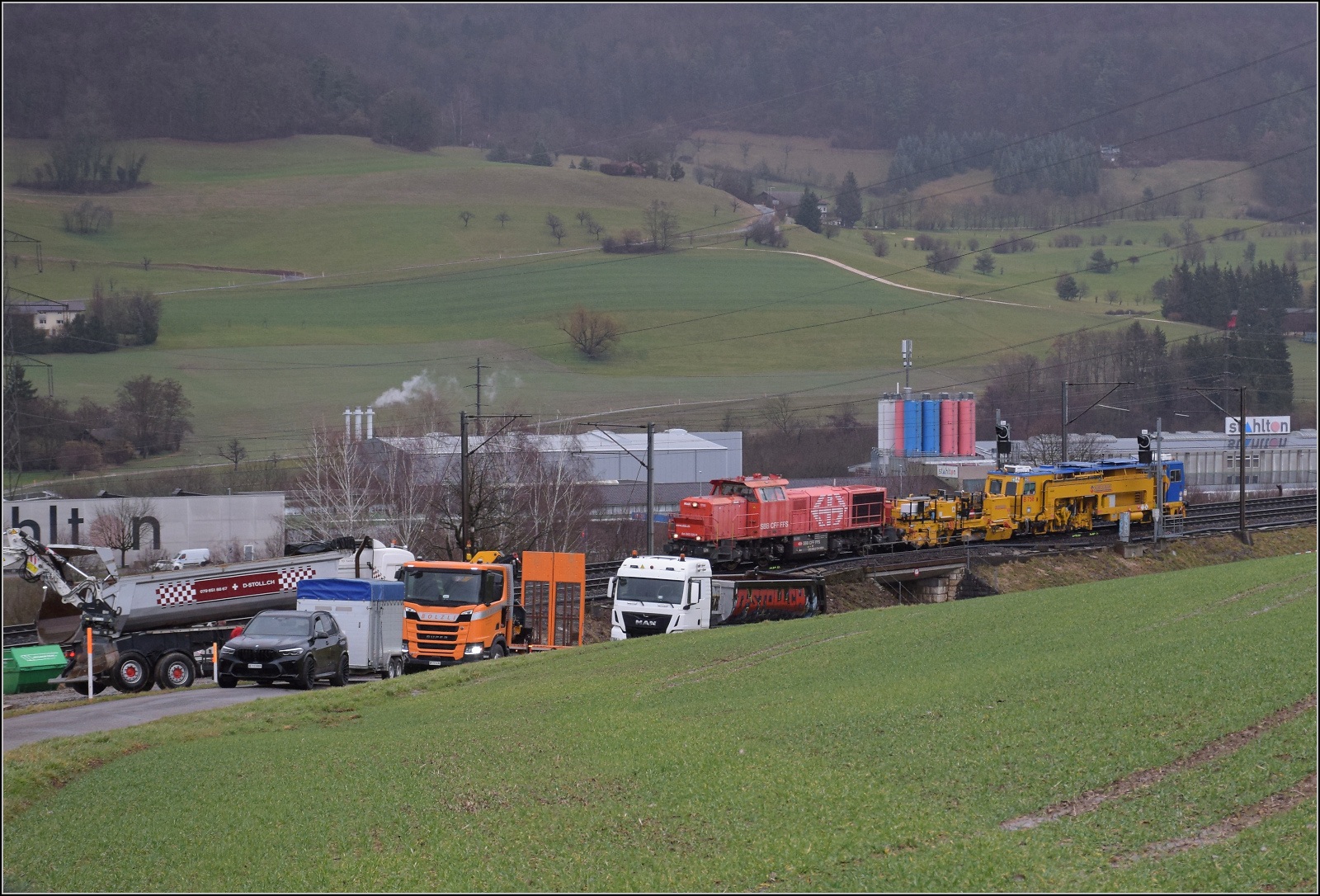 Schlechtwetter und ein Baustellendrama bei Frick. 

Am 843 020 der SBB Infrastruktur f�hrt mit einer Nivelier-Richt-Stopfmaschine B 758 von Scheuchzer (CH-SCHEU 40 85 9581 078) und dessen Anh�nger B 762 zum B�rsten des Schotterbetts ist offenbar auf einer Drehfahrt von Brugg zur�ck nun in Richtung Basel. Februar 2026.