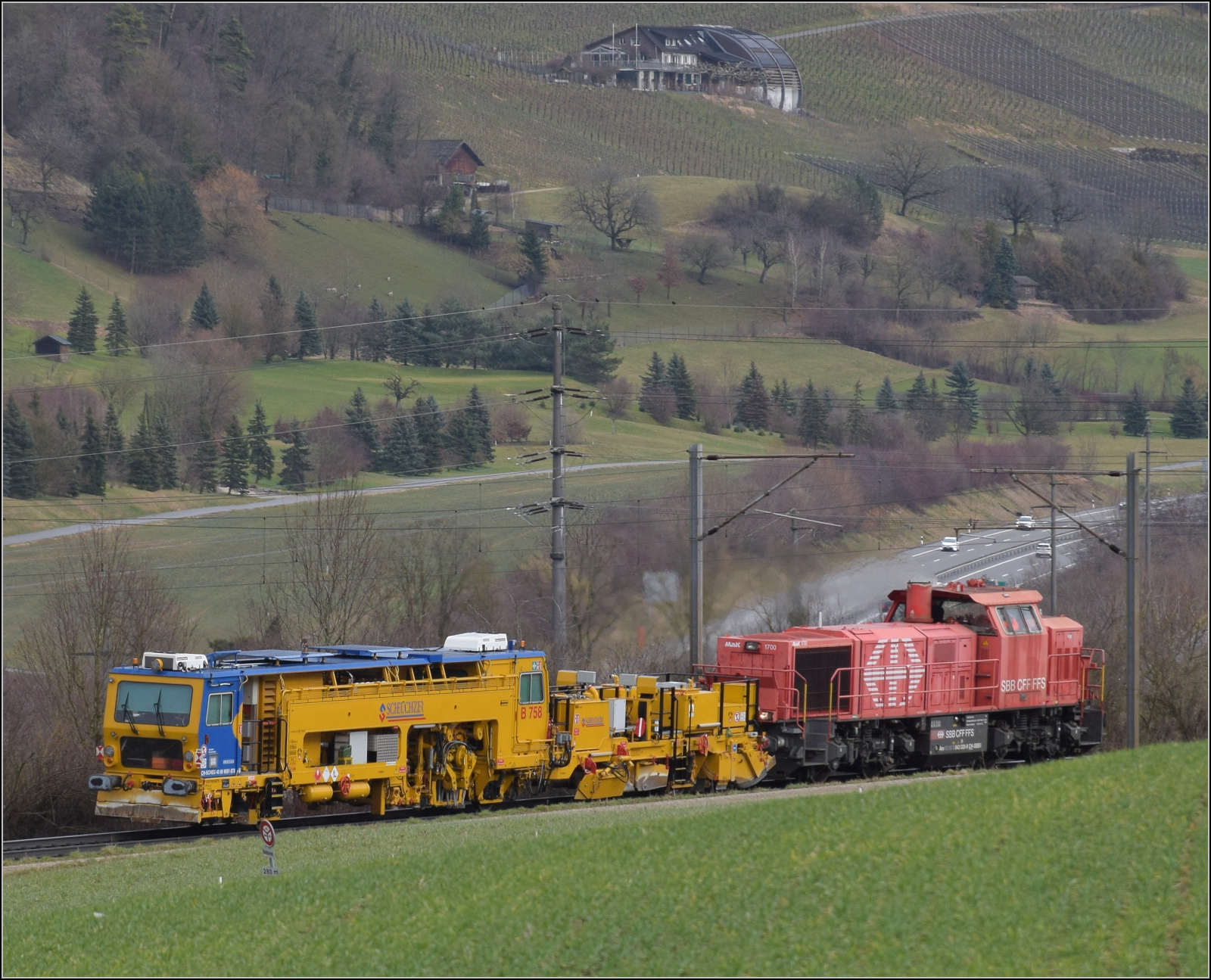 Schlechtwetter und ein Baustellendrama bei Frick. 

Am 843 020 der SBB Infrastruktur f�hrt mit einer Nivelier-Richt-Stopfmaschine B 758 von Scheuchzer (CH-SCHEU 40 85 9581 078) und dessen Anh�nger B 762 zum B�rsten des Schotterbetts in Richtung B�zberg. Februar 2026.