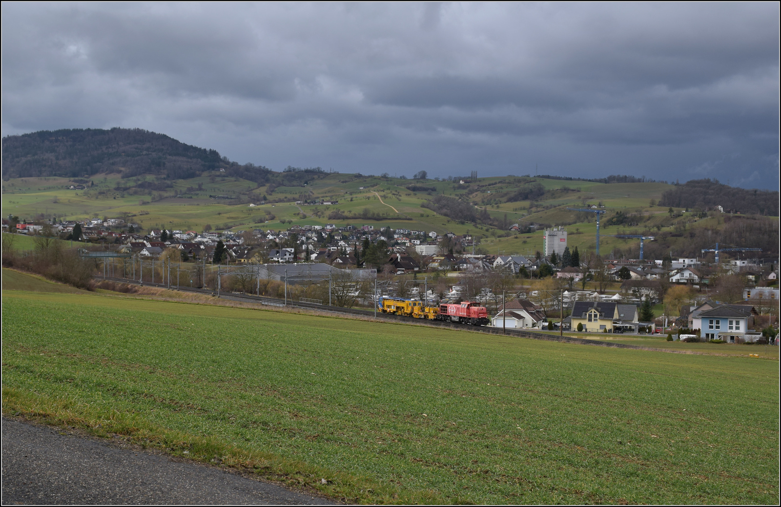 Schlechtwetter und ein Baustellendrama bei Frick. 

Am 843 020 der SBB Infrastruktur f�hrt mit einer Nivelier-Richt-Stopfmaschine B 758 von Scheuchzer (CH-SCHEU 40 85 9581 078) und dessen Anh�nger B 762 zum B�rsten des Schotterbetts in Richtung B�zberg. Februar 2026.