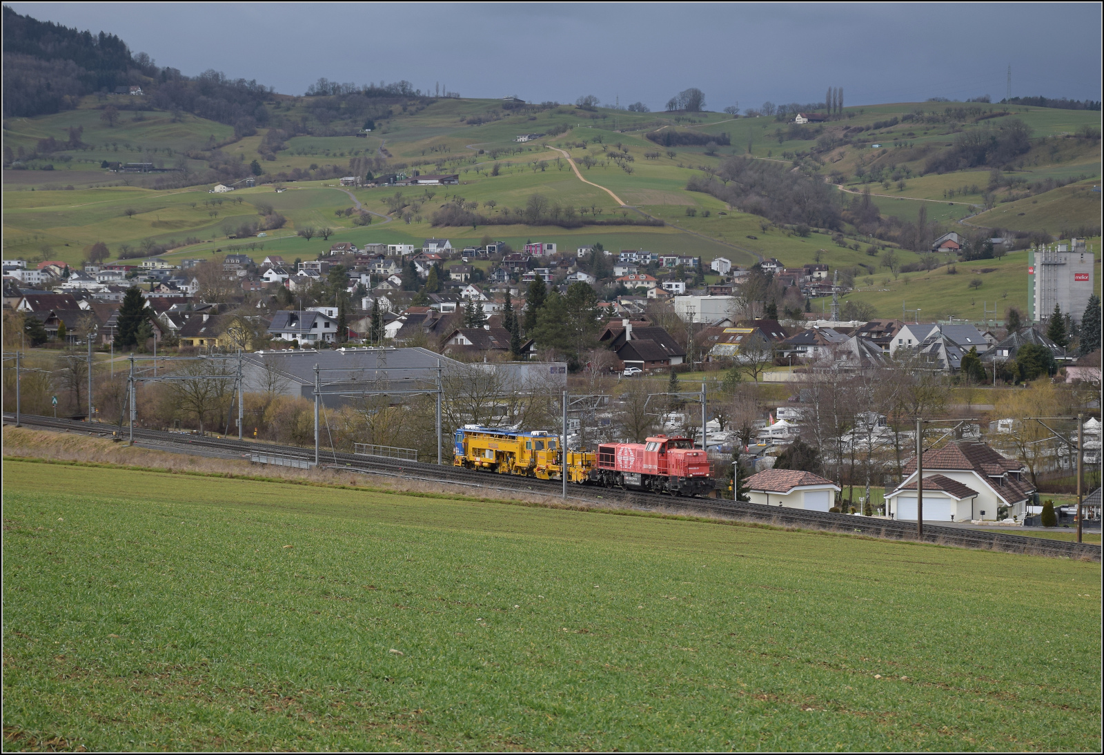 Schlechtwetter und ein Baustellendrama bei Frick. 

Am 843 020 der SBB Infrastruktur f�hrt mit einer Nivelier-Richt-Stopfmaschine B 758 von Scheuchzer (CH-SCHEU 40 85 9581 078) und dessen Anh�nger B 762 zum B�rsten des Schotterbetts in Richtung B�zberg. Februar 2026.