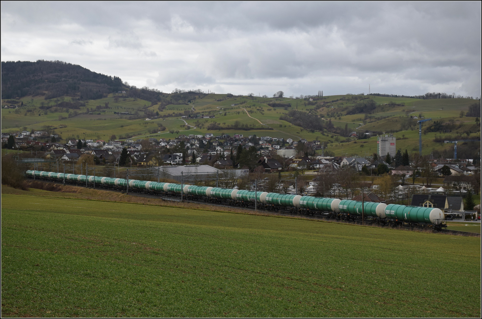 Schlechtwetter und ein Baustellendrama bei Frick. 

Der noch weitgehend unverschmierte Kesselwagenzug von GBX-Leasing mit farblich fast zur Lok passenden Wagen in ganzer L�nge und Sch�nheit. Er wird von Re 430 114 der WRS nach Muttenz gezogen. Februar 2026.