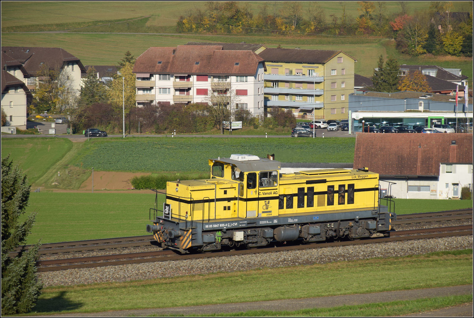 Sonnentag in Frick.

Bm 847 855 von Vanoli ist ein Sonderling aus Dnemark. Es wurden nur 10 Dieselloks vom Typ DHG 1200 BB von Henschel gebaut. Davon wurden zwei nach Schweden geliefert und drei an Privatbahnen nach Dnemark. Alle dnischen Loks fanden den Weg in die Schweiz, eine war zeitweise im Zementwerk Untervaz der Holcim eingesetzt, zwei sind im Dienst bei der Carlo Vanoli AG. Bm 847 855 'Meggen' war ursprnglich bei Hjrring Privatbaner im Einsatz und ist hier solo auf dem Weg Richtung Basel. Frick, November 2024.