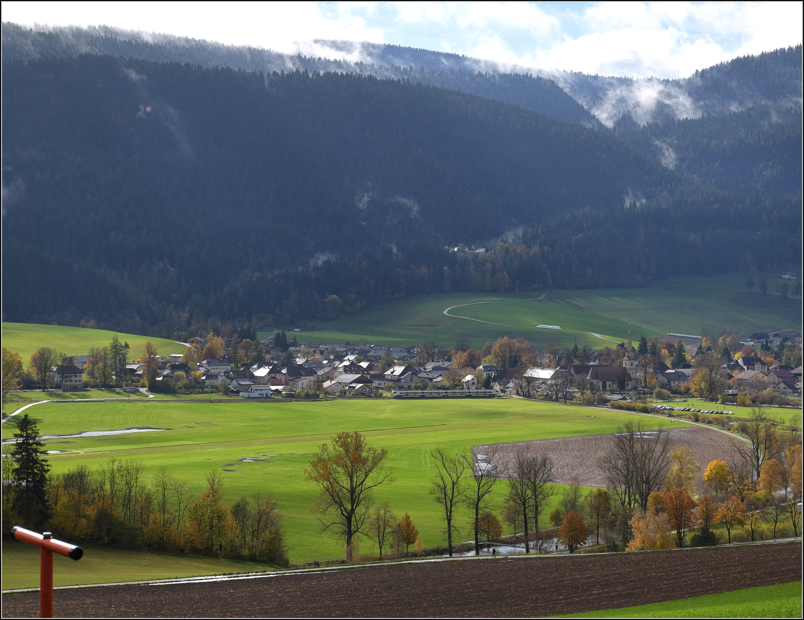 Überraschend fährt ein Flirt 3 von RER auf der Talstrecke im Val Travers durch. Môtiers, Oktober 2025.