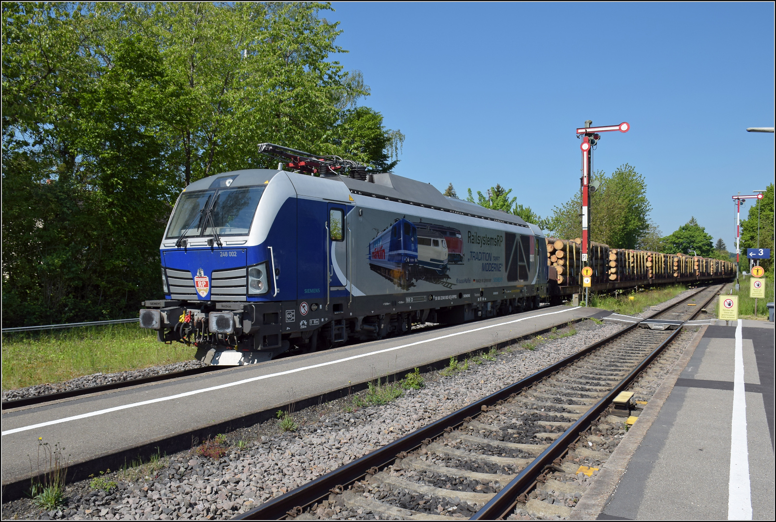 Unerwartet trifft  248 002 von Railsytems RP mit einem Holzzug aus Immendingen in Markdorf zur Kreuzung ein. Mai 2025.