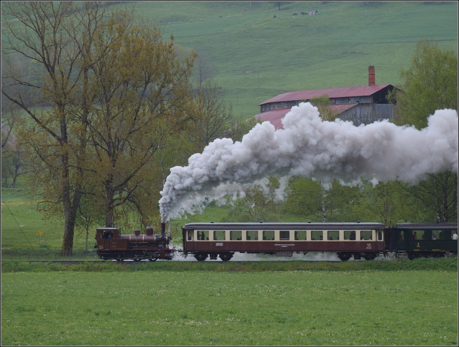 Vapeur Val-de-Travers: Train  Au fil de l'Areuse .

E 3/3 8511 nimmt zwischen La Presta und Travers Anlauf fr die Steigung. Mai 2023.