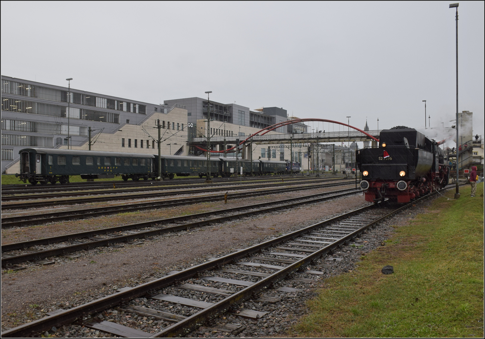 Weihnachtsmarktbesuch der EFZ.

52 7596 in strmendem Regen beim Auffllen der Wasservorrte auf dem ehemaligen Hafengleis im Bahnhof Konstanz. Unterdessen rangiert Re 421 379 ihren Wagenpark aus schweren Umbau-Stahlwagen auf Gleis 4.Dezember 2024.