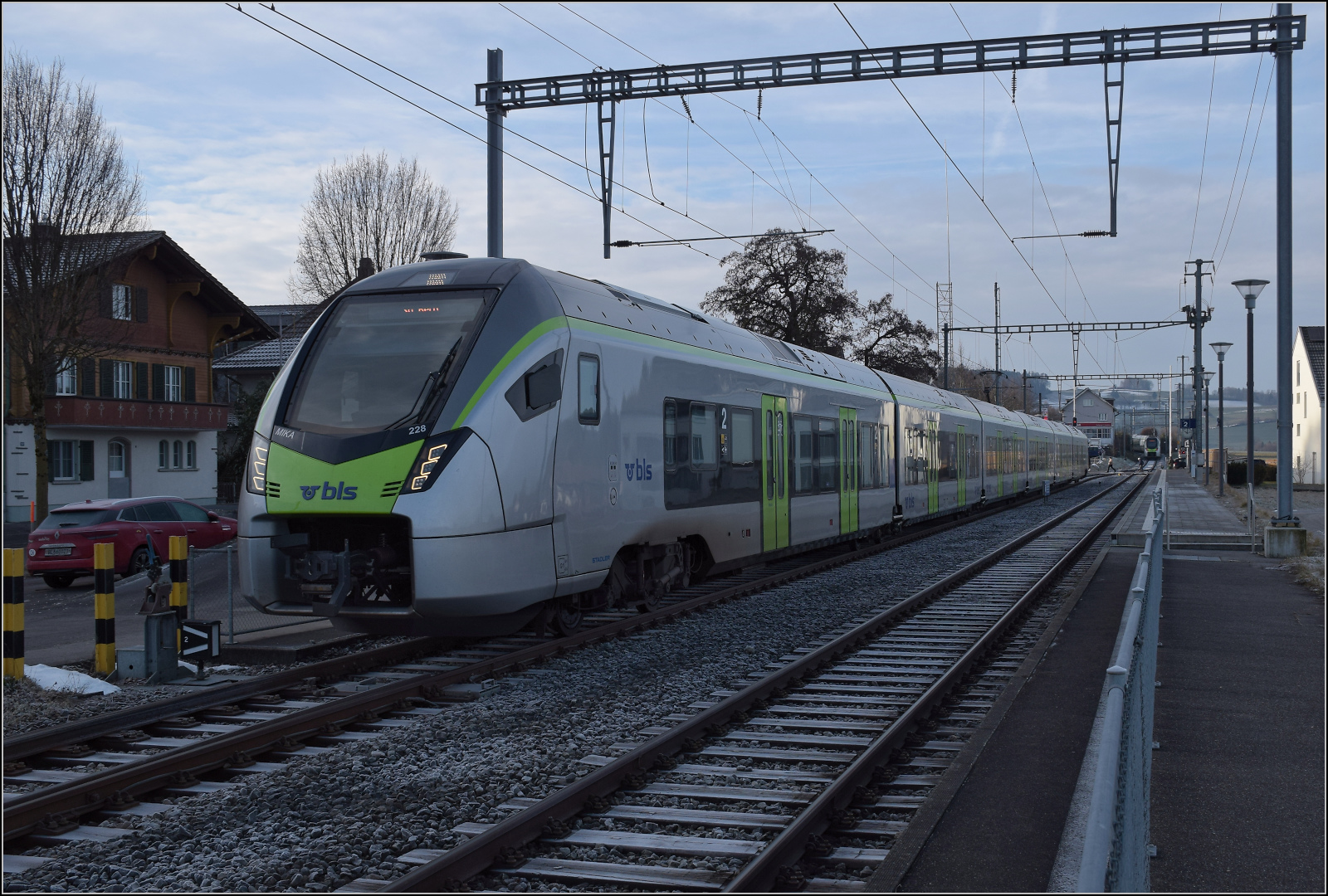 Zugkreuzung in Mittelhäusern. RABe 528 209 nach Schwarzenburg macht sich bereits auf die Socken, während RABe 528 228 nach Bern noch die Abfahrt abwartet. Januar 2026.