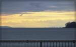 Das Wetter in Lindau war f�r die 18 478-Fahrt �u�erst bescheiden. Der Blick in den Hegau zeigte, dort h�tte eitel Sonnenschein geherrscht. Interessant jedoch die Wetterph�nomene, die sich von hier zeigten. Die schwebende Insel ist der Hohentwiel, rechts daneben der Hohenstoffeln. Links kaum zu erkennen Teile vom Randen und offenbar der Buchberg, dort f�hrt in fast 100 km Luftlinie die Sauschw�nzlesbahn. Februar 2023.
