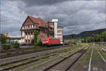 
185 302 mit einem Neuwagenpark in Weinheim. Juli 2023.