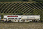Der Containertragwagen 31 80 4556 572-4 RIV D-AAEC Sgns im Zugverband des B�umlezugs mit 264 003. Buggingen, September 2026.