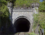 Das Westportal des Rappensteintunnels in Laufenburg (Baden). Das Tunnelportal mit Zyklopenmauerwerk demonstriert den Sieg �ber das harte Gneisgestein des 337 m langen Rappensteins, das erst nach vier Jahren Bauzeit fertiggestellt werden konnte. Dynamit wurde erst ein Jahrzehnt nach dem Bau des Tunnels erfunden und so kam es zu einer Kosten�berschreitung von 10.000% und einer Bauverz�gerung. M�glicherweise ist er auch die erste Ortsumfahrung in Form eines Tunnels, denn urspr�nglich sollte die Bahnstrecke durch die Altstadt von Laufenburg f�hren, womit die H�lfte der Laufenburger H�user zerst�rt worden w�re. Kein Wunder, dass sich die Laufenburger mit Z�hnen und Klauen schlie�lich erfolgreich dagegen wehrten. April 2026.