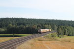 218 105 überführt eine Stopfmaschine und Bauwagen bei Neudes gen Hof.