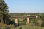 185 637-6 erreicht das Viadukt von Beratzhausen mit einem leeren Autotransportzug.