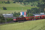 Re 4/4 II 11324 mit einem leeren Autozug bei Frick, Juni 2025.