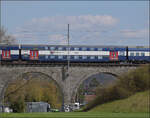 Der 1. Klasse-Doppelstockwagen mit Hocheinsteig der S-Bahn Zürich mit Re 450 038 'Wollishofen' auf dem Eglisauer Rheinviadukt. April 2026.
