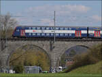 Der Doppelstocksteuerwagen Bt mit Hocheinsteig der S-Bahn Zürich mit Re 450 038 'Wollishofen' auf dem Eglisauer Rheinviadukt. April 2026.