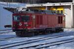 Die bereits etwas betagte Zweikraftlok Gem 4/4 801 aus dem Jahr 1966 vor dem Fahrzeugschuppen in Pontresina. Januar 2023.