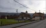 Dambelin mit Kirche Saint-Desle-et-Bénigne in Franche-Comté. Im Hintergrund ist der Lomont zu sehen, der die Gegend weithin sichtbar beherrscht. Bei guter Sicht ist der Berg auch problemlos vom Schwarzwald zu erkennen, da er in der burgundischen Pforte die markanteste Erhebung ist. März 2023.